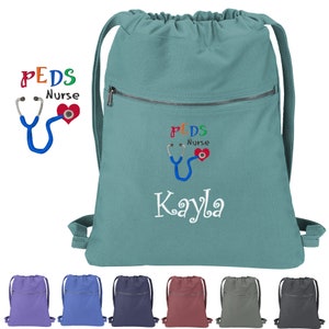 May include: Teal drawstring backpack with a zippered pocket and embroidered text that reads "PEDS Nurse Kayla" with a stethoscope and heart graphic.