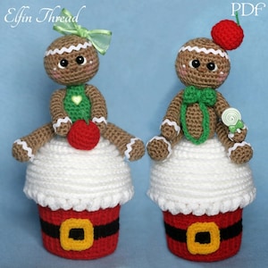 Puede incluir: Dos personas de jengibre de crochet, una con un lazo verde y la otra con una cereza roja en la parte superior, están sentadas sobre bases de cupcake de crochet blanco y rojo. Los cupcakes tienen un cinturón negro alrededor del medio.