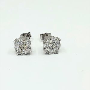 May include: A pair of silver stud earrings with a cluster of small diamonds in the center of each earring.