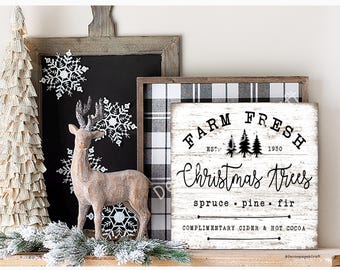 May include: A Christmas-themed display featuring a paper tree, a deer figurine, and a sign that reads "Farm Fresh Christmas Trees." The sign is white with black text and a plaid background. Decorative snowflakes are also present.
