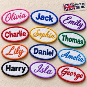 Puede incluir: Una colección de doce parches bordados de forma ovalada con centros de tela blanca y bordes de colores. Cada parche presenta un nombre único en varias fuentes y colores de hilo. Una pequeña etiqueta en la esquina dice MADE IN THE UK.