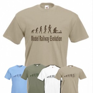 May include: Four t-shirts featuring a humorous graphic depicting the evolution of man, culminating in a man building a model train. The text on the t-shirt reads "Model Railway Evolution". The t-shirts are available in four colours: light blue, khaki, white, and dark khaki.