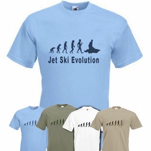 Könnte beinhalten: Hellblaues T-Shirt mit einer Grafik, die die Entwicklung des Jetski-Fahrens darstellt. Das Design zeigt eine Entwicklung von affenähnlichen Figuren zu einer Person auf einem Jetski. Der Text "Jet Ski Evolution" steht darunter. Weitere Shirts in Oliv, Weiß und Beige sind ebenfalls zu sehen.