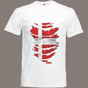 Könnte beinhalten: Weißes T-Shirt mit einem zerrissenen Design, das die dänische Flagge darunter freilegt.