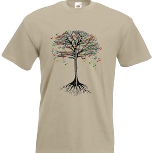 Puede incluir: Una camiseta beige con una silueta de árbol negro con notas musicales de colores en las ramas. El árbol tiene raíces y está centrado en la camiseta.