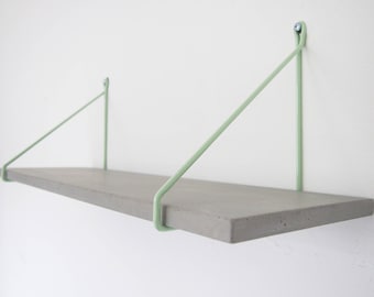 uphangen - rack of a handmade concrete shelf held by two steel tube brackets in mint and black