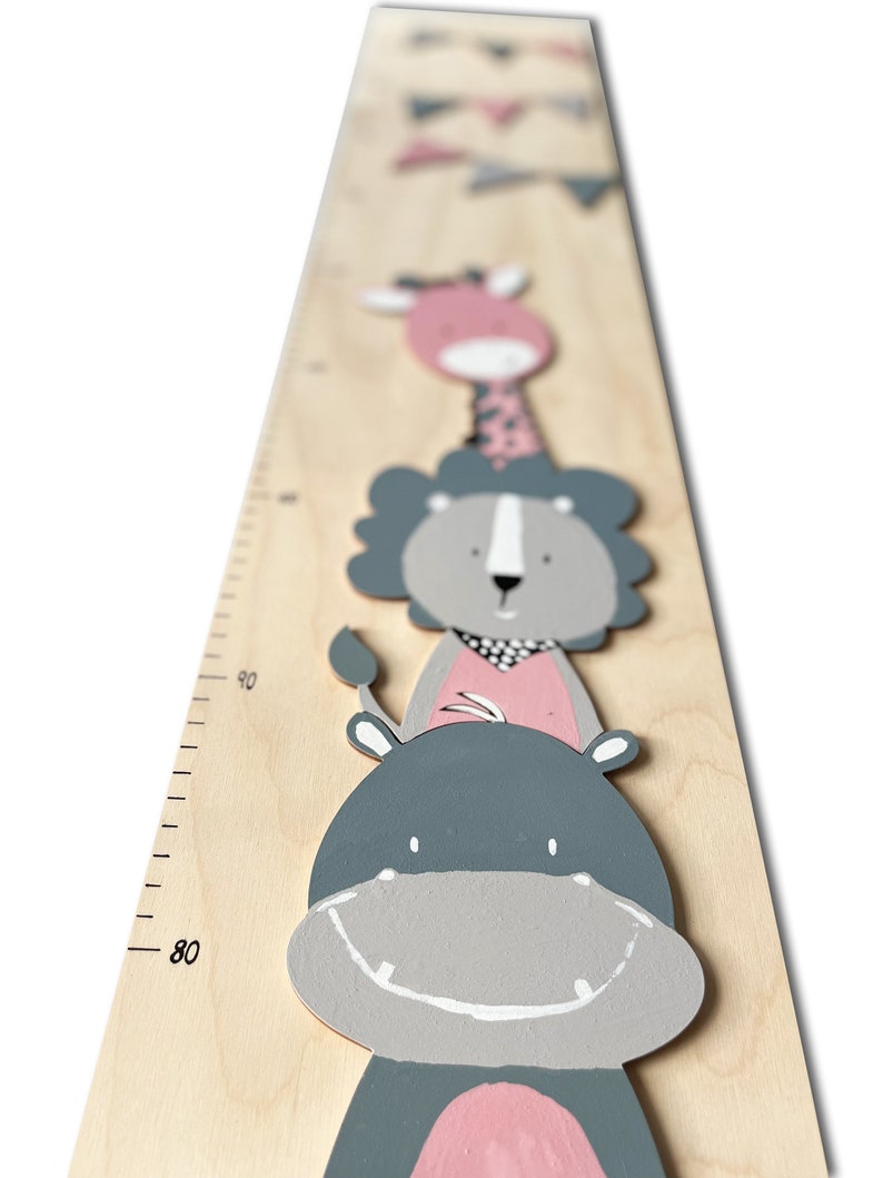 May include: A wooden growth chart with a ruler marked in inches. The chart features a gray and pink painted hippopotamus, lion, and giraffe.