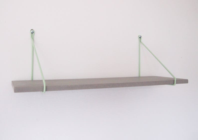May include: A gray wooden shelf with light green rope supports attached to the wall.