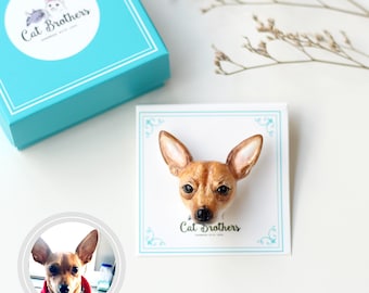May include: A handmade polymer clay brooch of a brown and white chihuahua dog head. The brooch is on a white card with the text "Cat Brothers Handmade with Love".