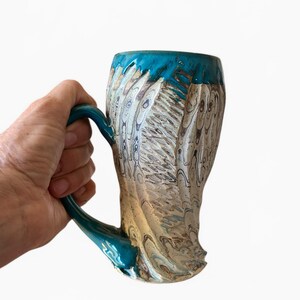 May include: A set of three ceramic mugs with a speckled, matte finish. The mugs are in shades of cream, light gray, and dark gray. Each mug has a simple, minimalist design, perfect for coffee or tea.