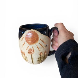 Taza artesanal de 473 ml (16 oz) con diseño de flores y sol tallados: pieza única de cerámica tallada y pintada para amantes del café y el té.