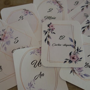 May include: Twelve cards with floral designs and gold accents. Each card features a number and the word "mois" (French for month) or "an" (French for year). The cards are labeled with numbers 1 through 12 and the text "Cartes-&eacute;tapes".