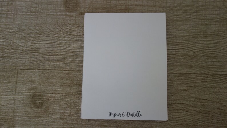 May include: A blank white card with the text "Papier & Dentelle" printed in black at the bottom.