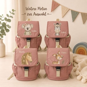 Könnte beinhalten: Vier altrosa Rucksäcke mit beigen Riemen und schwarzen Schnallen. Jeder Rucksack zeigt eine individuelle Tierillustration: Koala, Zebra, Pferd und Reh. Die Namen Emilia, Selina, Marlis und Clara sind neben den Tieren aufgedruckt.