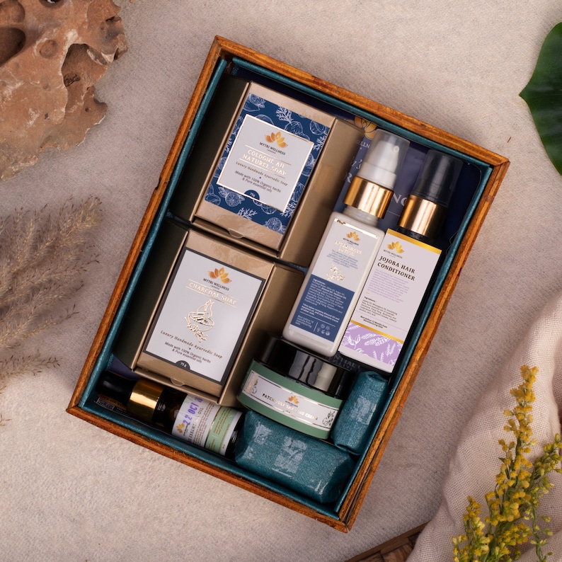 Puede incluir: Una caja de madera llena de productos de belleza naturales. La caja contiene dos barras de jab&oacute;n, una botella de acondicionador para el cabello, una botella de suero facial, un frasco de crema facial y una peque&ntilde;a botella de aceite esencial. Todos los productos est&aacute;n etiquetados con el nombre de la marca "Mythe Wellness".