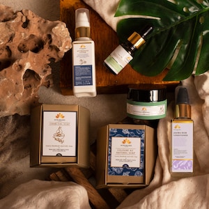 Puede incluir: Una colecci&oacute;n de productos de belleza naturales que incluyen un jab&oacute;n de carb&oacute;n vegetal, un jab&oacute;n de colonia, un acondicionador para el cabello de jojoba, una loci&oacute;n para despu&eacute;s del afeitado y un aceite esencial. Los productos est&aacute;n empaquetados en cajas doradas y azules con un tema natural.
