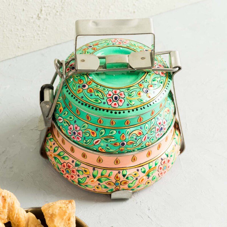 Decorative steel food containers. These traditional Indian containers are made from food safe steel and enamel coated. Skilfully hand-decorated with a bright flower pattern. These boxes are decorated in complementing pastel colours.