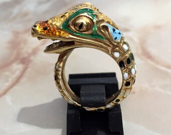 May include: A gold ring with an enamel alligator head design. The alligator's eyes are green, and the body is decorated with black and white spots.