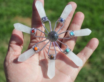 May include: A white crystal chakra set with seven clear quartz points and a labradorite center stone. Each point is accented with a colored gemstone.