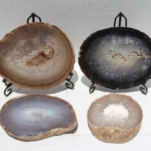 May include: Four agate slices on metal stands. The agate slices are in various colors, including brown, black, and gray. The agate slices are polished and have a natural, organic look.