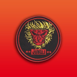 May include: Black and red embroidered patch with a lion's head in a flame design. The text "The Jungli" is written below the lion's head.