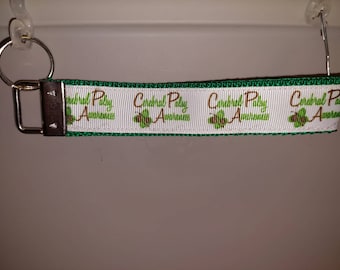 May include: White and green key chain with the text "Central Palsy Awareness" and a green shamrock design.