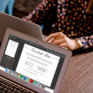 May include: Two MacBook Air laptops on a wooden table. The screen of the front laptop displays a "Flowchart Plan" document. The other laptop is open, and a person is working on it. The person is wearing a floral print top.
