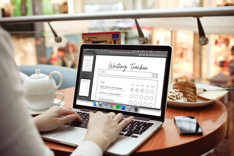 May include: A laptop displaying a "Writing Tracker" template, with a teapot and cake on a table. The screen shows a progress chart with checkboxes. The text "Writing Tracker" is at the top. A smartphone sits on the table.