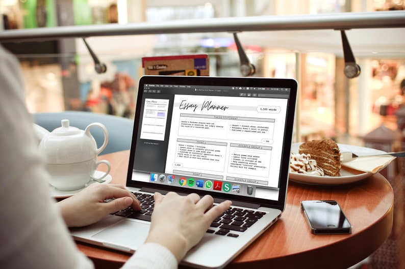 May include: A person using a laptop with an "Essay Planner" displayed on the screen. A white teapot and cup sit on the table, along with a slice of cake and a smartphone. The laptop screen shows a writing template.