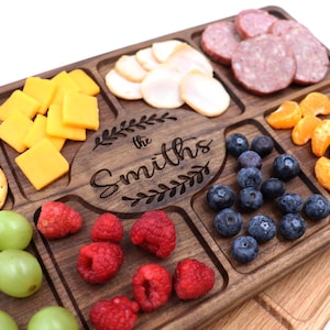 Walnut wood charcuterie board with white background 
With
Blueberries, raspberries, Oranges, Ham and Cheese spread out on top