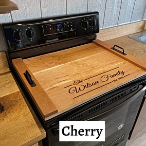 Full Size Cherry Stovetop cover sitting on a range with an engraving on the lower half of it.