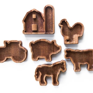 May include: Wooden farm animal shapes with a barn and tractor. The shapes are hollow and can be used as storage containers.