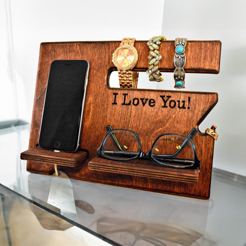 May include: Wooden organizer with slots for a watch, glasses, and a phone. It has a shelf for jewelry and the words "I Love You!" are engraved on the front.