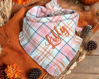 May include: A pink and white plaid bandana with frayed edges and the name "Lilly" embroidered in orange thread.