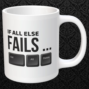 May include: White ceramic mug with the text "IF ALL ELSE FAILS..." and keyboard keys Ctrl, Alt, and Delete. The mug has a curved handle and is set against a dark background with a repeating pattern.