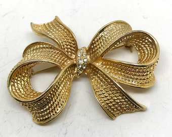 Broche vintage avec nœud/ruban en strass transparents dorés -- signée