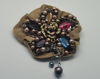 Broche vintage de tela con técnica mixta, pedrería y flores de cuentas.