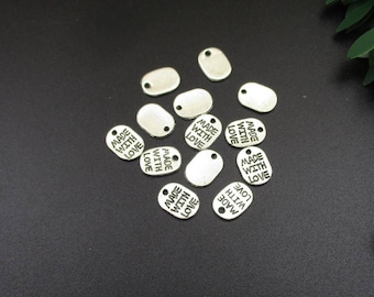 Puede incluir: Etiquetas de metal plateado con el texto "Made with Love" impreso en ellas.