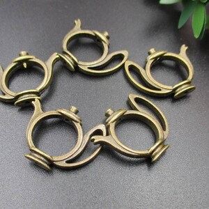 May include: Six antique gold-toned metal teapot charms. Each charm features a detailed teapot design with a handle and spout.