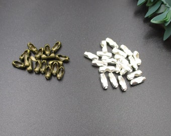 Puede incluir: Dos pilas de conectores de cadena de metal, una pila es plateada y la otra es bronce.
