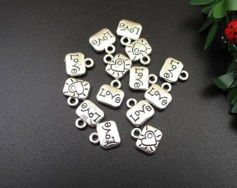 May include: Silver charm pendants with the word "love" and a heart design. The charms have a loop for attaching to a bracelet or necklace.