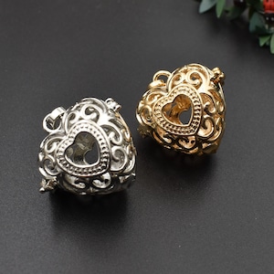 May include: Two heart-shaped metal charms with intricate designs. One charm is gold and the other is silver.