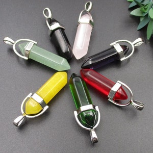 May include: Eight crystal point pendants with silver settings. The pendants are in a variety of colours, including green, yellow, red, pink, black, and purple.