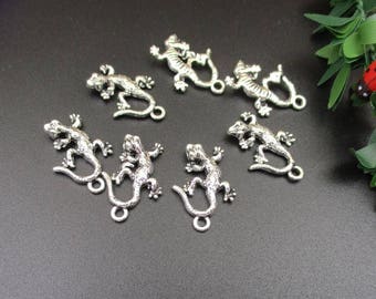 May include: A set of seven silver-toned lizard charms with loop attachments. The lizards are in various poses with detailed scales and textured surfaces.