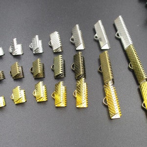 May include: Assortment of gold and silver metal cord end caps in various sizes. The cord end caps have a decorative, textured design and a loop at the top.