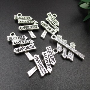 10 dijes de 25 x 14 mm con la palabra "éxito, dinero y felicidad" - p1859