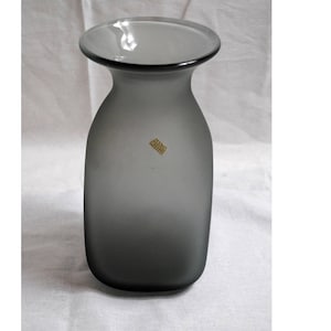 May include: A gray frosted glass vase with a wide mouth and a rounded base.