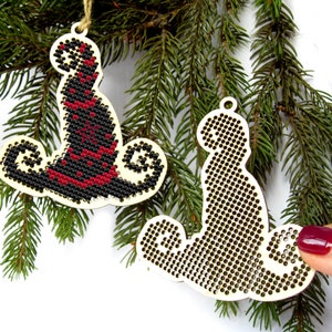May include: Two unfinished wooden Christmas ornaments shaped like a witch's hat and a cat. The ornaments are ready to be decorated with embroidery floss.