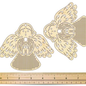 Peut inclure: Deux ornements en bois en forme d'ange avec des motifs d&eacute;coup&eacute;s complexes. Chaque ange a des ailes d&eacute;taill&eacute;es, une &eacute;toile au-dessus de la t&ecirc;te et un corps avec un motif de petits trous. Les anges mesurent environ 7.6 cm de haut.