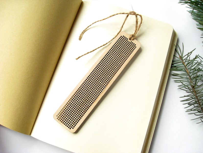 Peut inclure: Un marque-page en bois avec un motif de grille pour la broderie au point de croix. Le marque-page est attach&eacute; &agrave; une ficelle en ficelle brune.